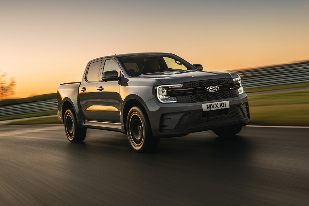 Ένα σκούρο γκρι Ford Ranger Platinum κινείται σε μια πίστα κατά το ηλιοβασίλεμα.