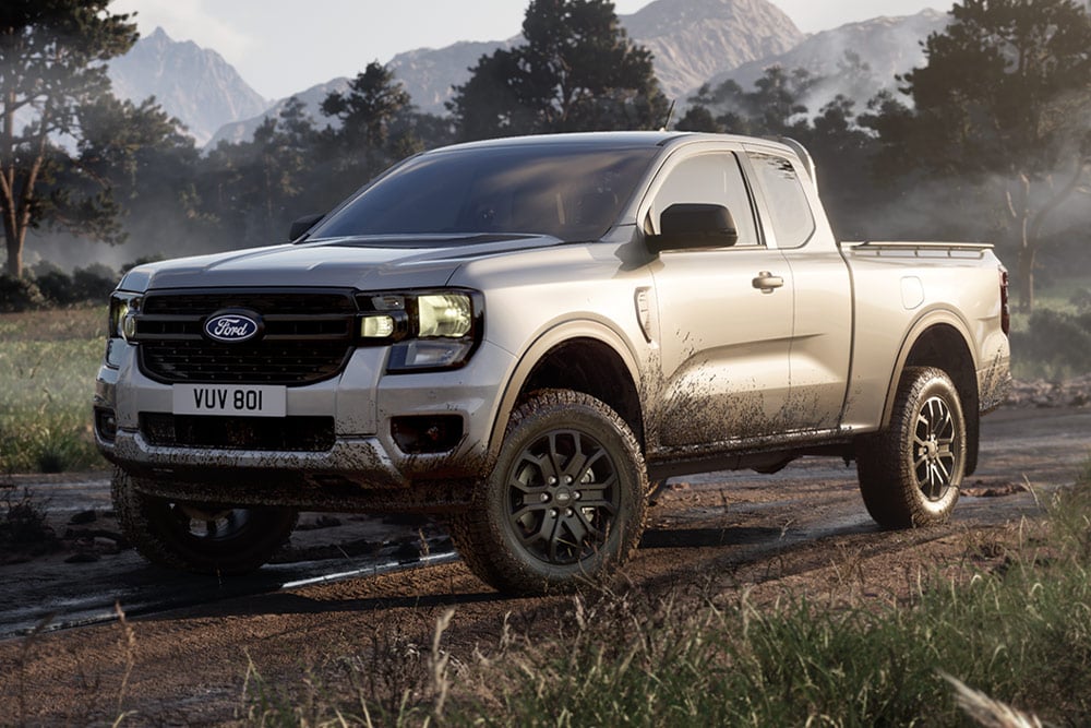 Ασημί Ranger Super Cab που κινείται σε χωματόδρομο μέσα σε ένα γραφικό τοπίο.