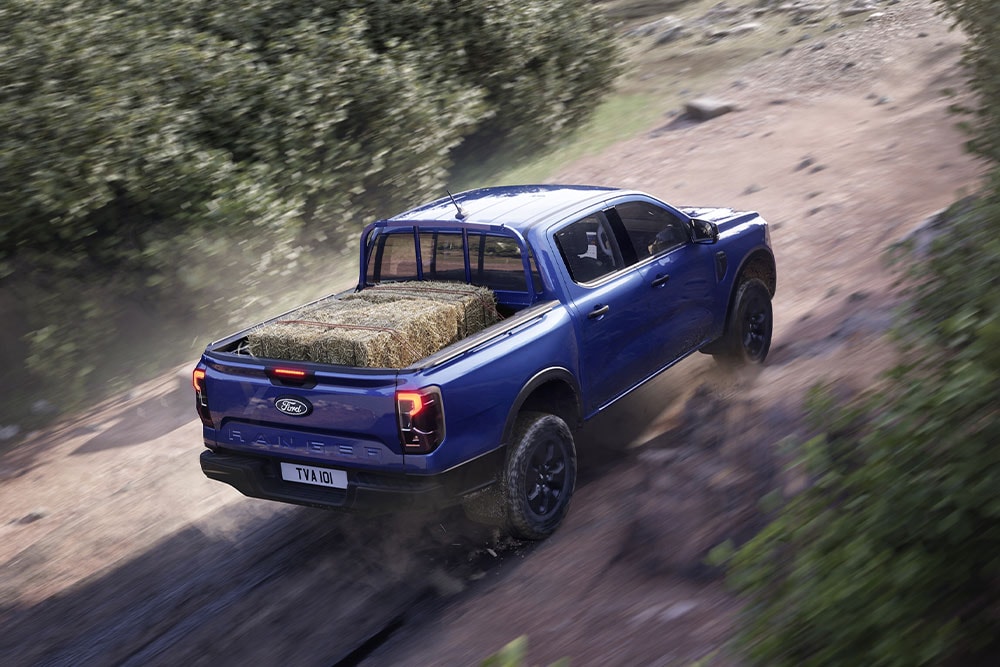 Πίσω όψη από ψηλά ενός μπλε Ford Ranger που κινείται σε χωματόδρομο.