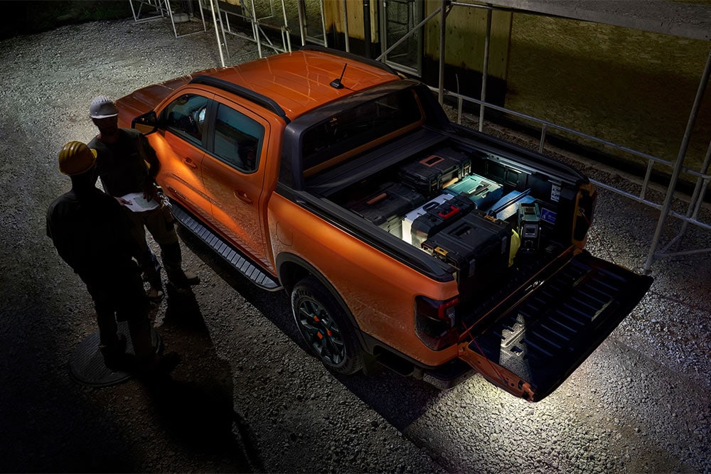 Άποψη από ψηλά ενός πορτοκαλί Ford Ranger Wildtrak τη νύχτα, με ενεργοποιημένο τον εξωτερικό φωτισμό σε ζώνες.