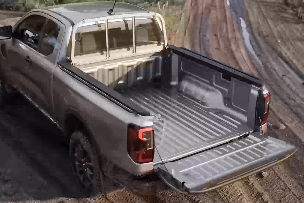 Ασημί Ford Ranger XLT Super Cab σταθμευμένο σε λασπωμένη επιφάνεια με ανοιχτή την πίσω πόρτα, με θέα από ψηλά.