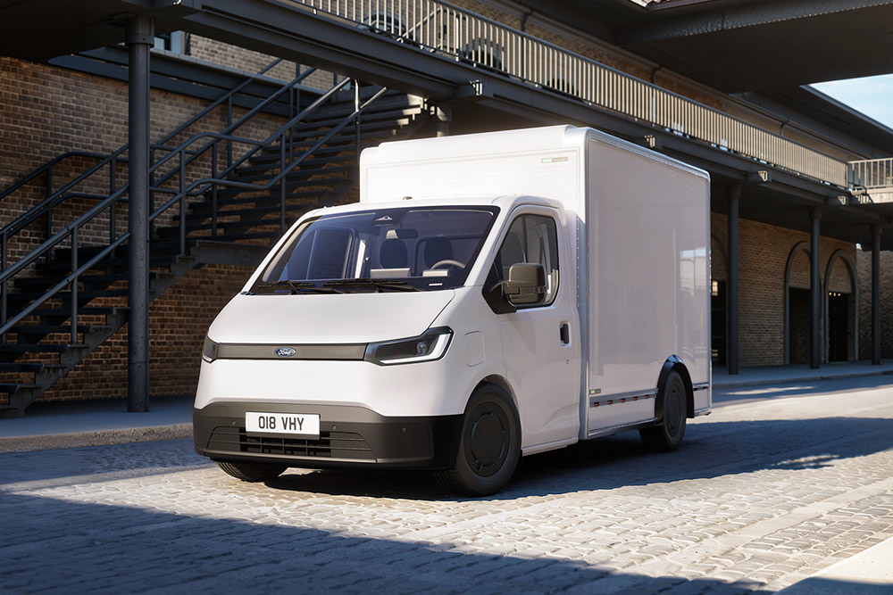 Λευκό Ford Transit City® Chassis Cab σταθμευμένο μπροστά από ένα κτίριο από τούβλα.