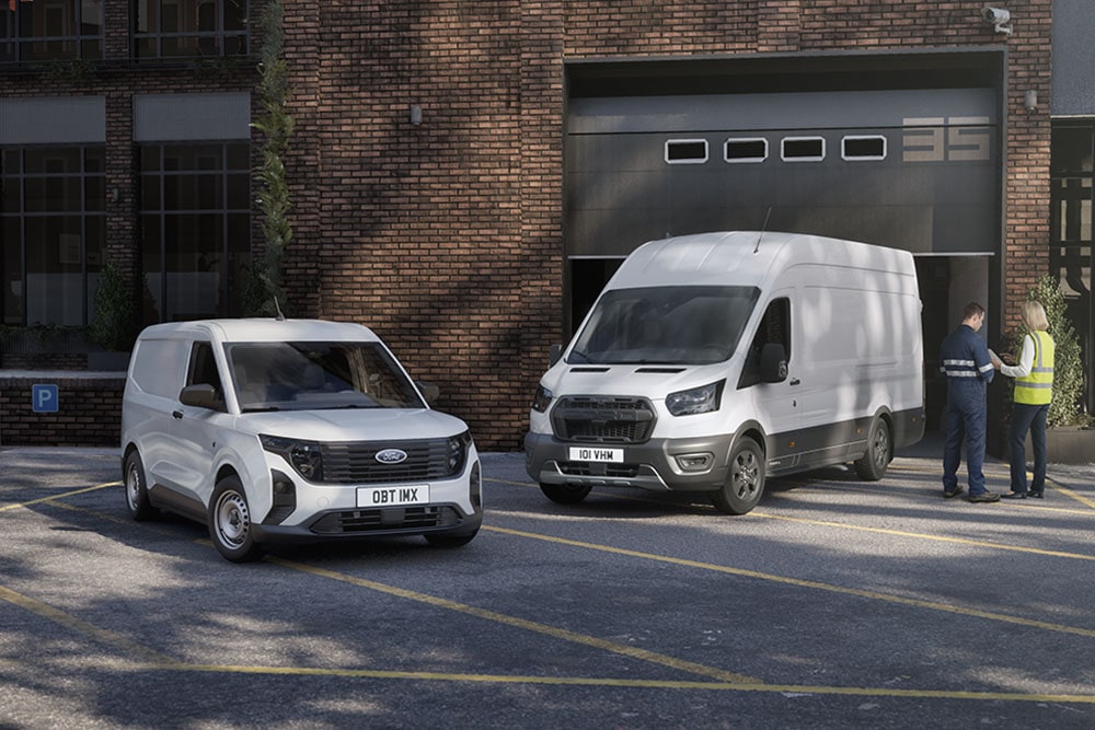Ένα Ford Transit Courier και ένα Ford Transit, λευκά, παρκαρισμένα δίπλα σε κτίριο, με εργαζόμενους σε γιλέκα ασφαλείας.