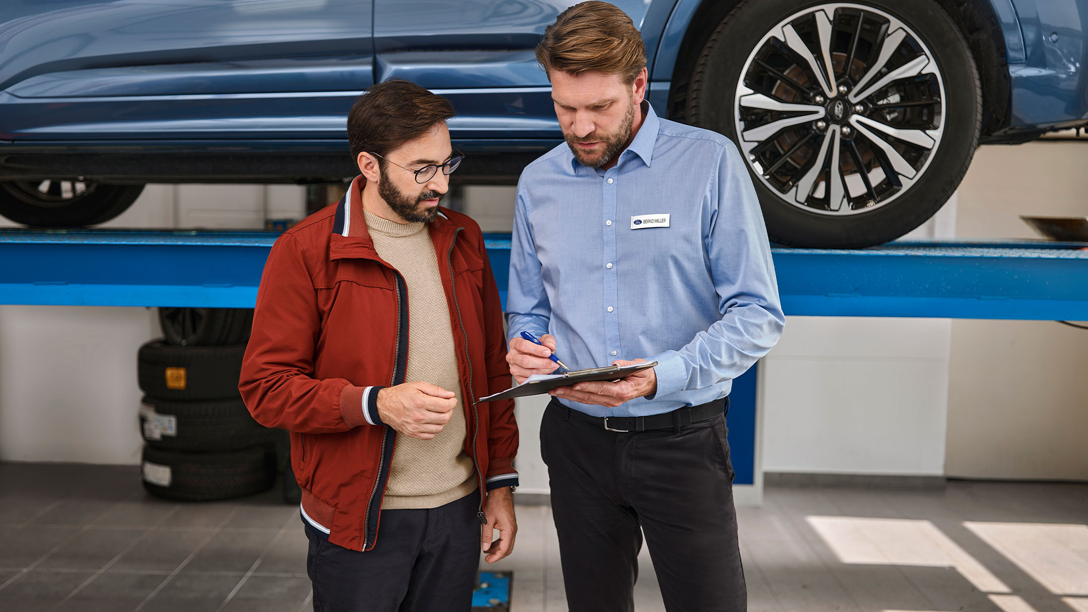 Ένα άτομο μιλάει με έναν ειδικό της Ford σε ένα κατάστημα Ford service