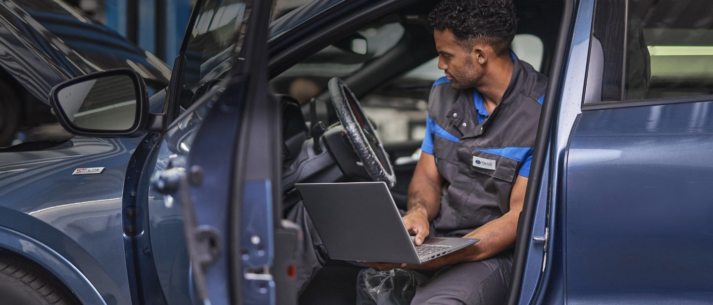 Ford service repair engineer, sitting in a car