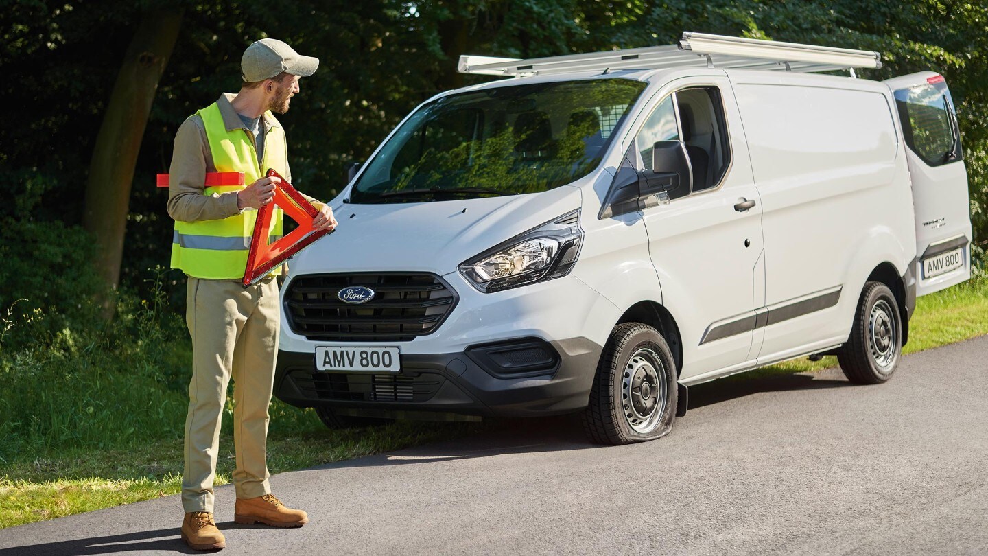 Ένας άνδρας μπροστά σε αυτοκίνητο Ford στην άκρη του δρόμου