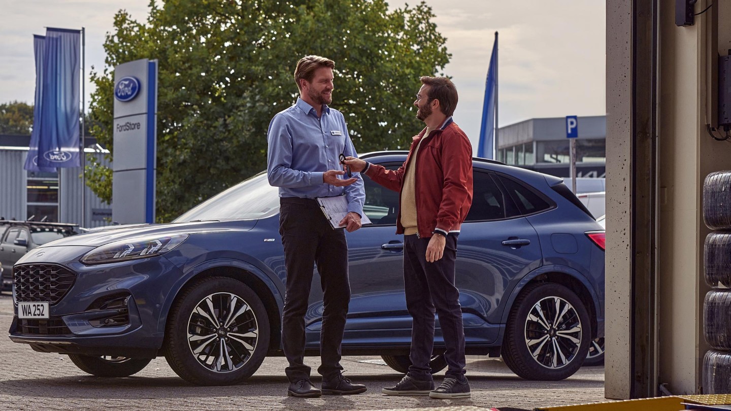 Man handing keys to Ford veichle to service engineer