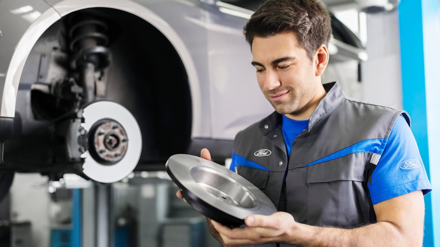 Τεχνικός Ford κρατάει δισκόπλακα από τα εμπρόσθια φρένα